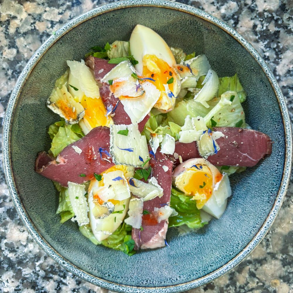 Petite salade au magret de canard fumé, œuf BIO mollet, croûtons, copeaux de Sainte-Maure sec et vinaigrette poivrons piment d’espelette